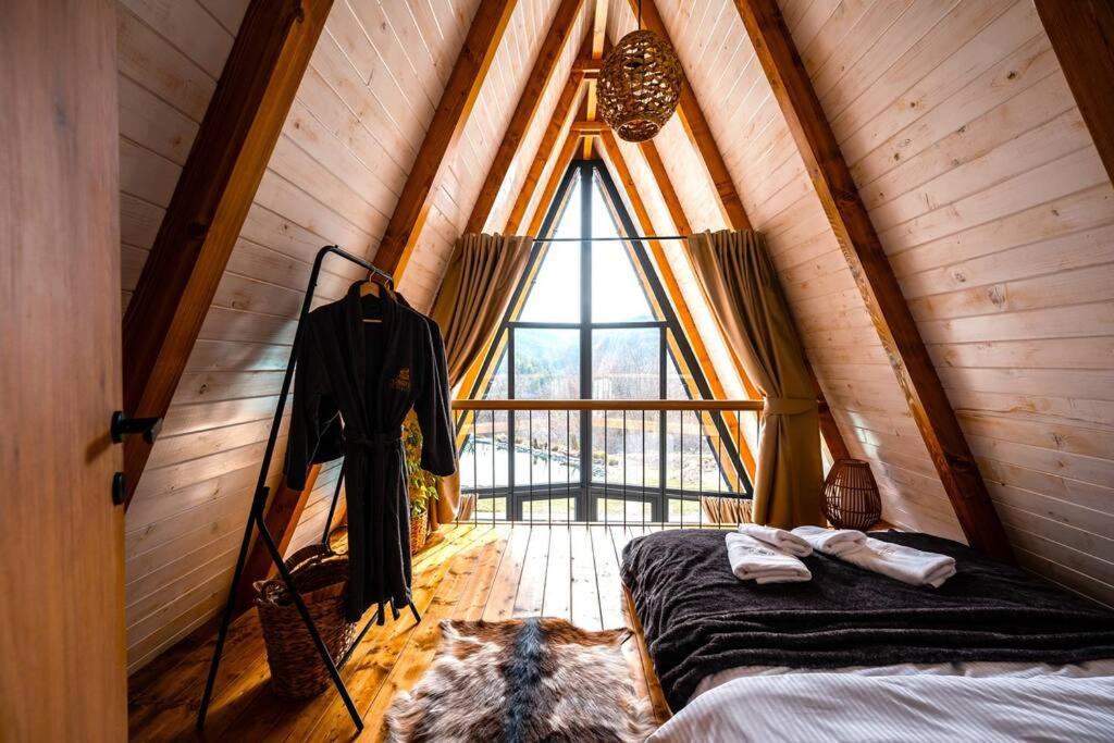 een zolderkamer met een bed en een raam bij Forrest Relax & Spa in Rakovac