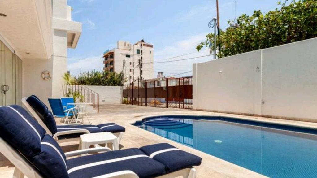 a swimming pool with lounge chairs and a swimming pool at Hermoso Departamento Nuevo in Acapulco