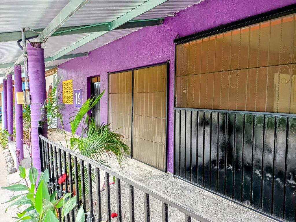 un edificio púrpura con una valla delante en ORidleys Hostel16, en Barra de Potosí