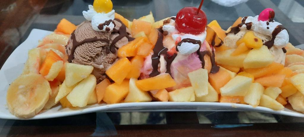 un plato de comida con helado y fruta en las laureles de las americas, en Huánuco