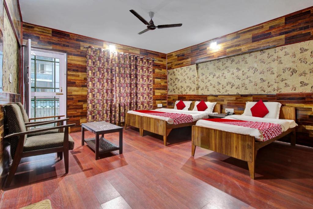 a room with two beds and a chair in it at Hotel Ab-i-Hayat in Srinagar