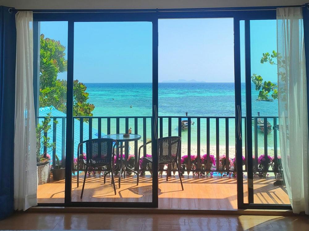 a room with a view of the ocean from a balcony at Lipe Sunrise Beach House in Ko Lipe