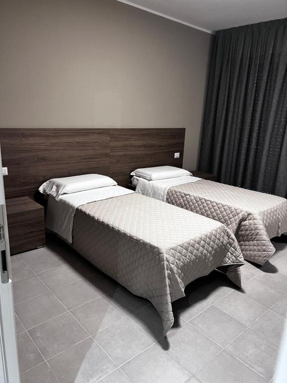 two beds sitting in a room with at Bella Napoli albergo Chiari in Chiari