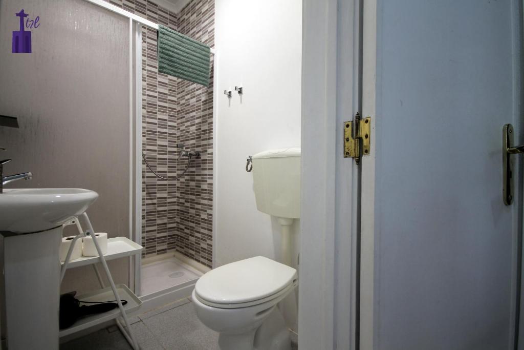 リスボンにあるLisbon South Apartmentの白いトイレと洗面台のあるバスルーム