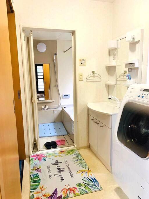 泉佐野JOY IN民宿两站关西机场一站奥莱，整租，提供机场接送服务,步行可达便利店、免税购物中心、药妆店的一间小浴室,配有水槽和毛巾,位于地板上