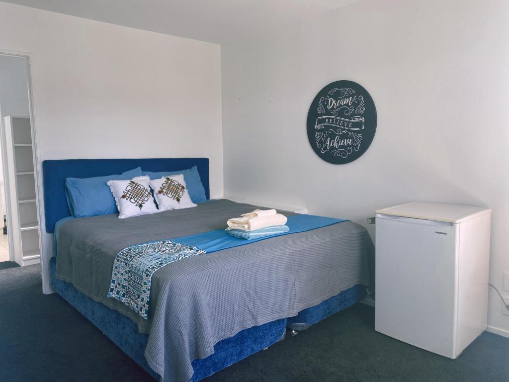 a bedroom with a blue bed with a chalkboard on the wall at A private Large master room with en-suite in Auckland