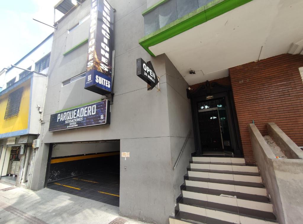Zugang zu einem Gebäude mit einer Treppe, die in eine Garage führt in der Unterkunft HOTEL SENSACIONES SUITE in Medellín