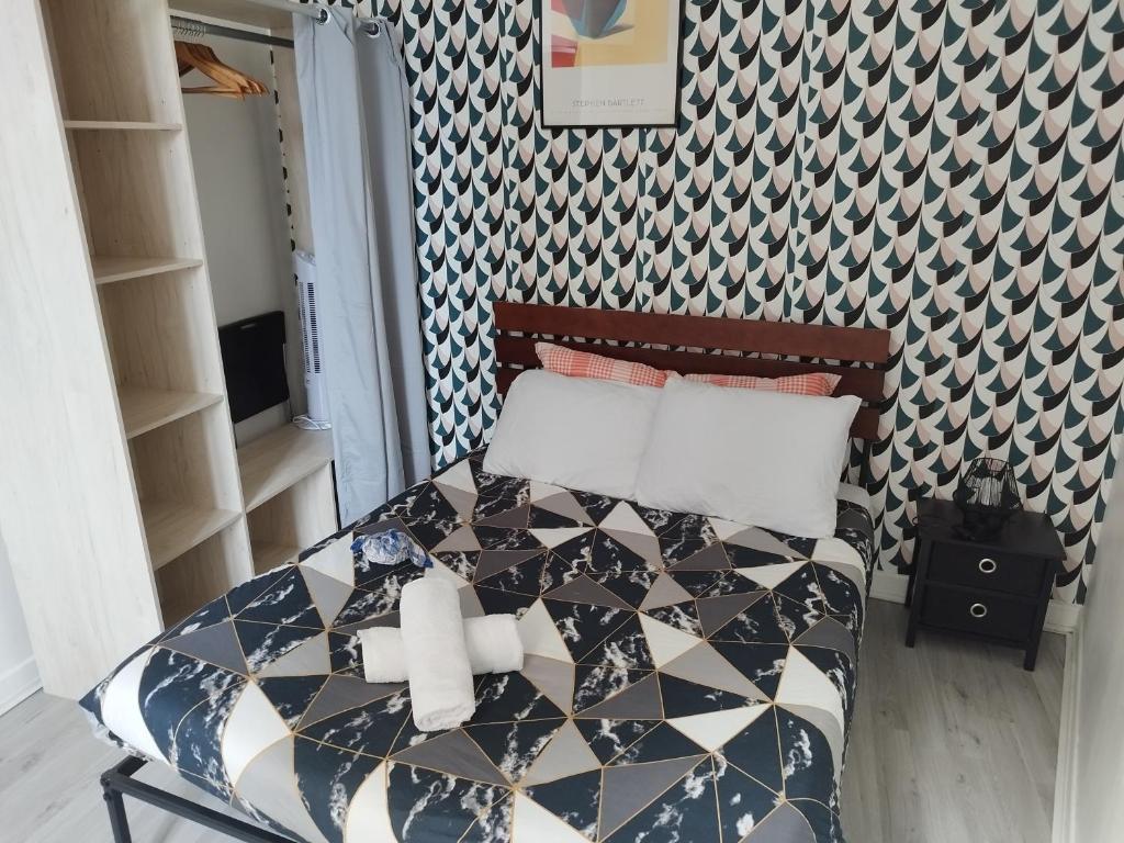 1 dormitorio con 1 cama con pared estampada en Cosy T2 à 5 minutes de Metro 12-Proche Paris-Stade de France en Aubervilliers