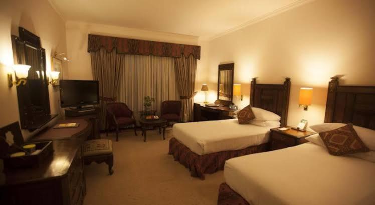 a hotel room with two beds and a television at B&b Mumtaz City in Islamabad