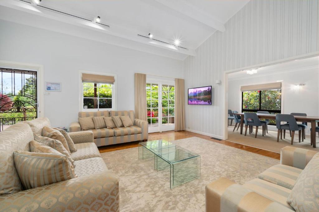 a living room with couches and a dining room at Lynwood Gardens in Blackheath