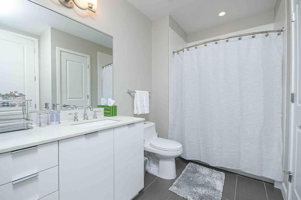 a white bathroom with a toilet and a sink at The Bleu Oasis in Atlanta