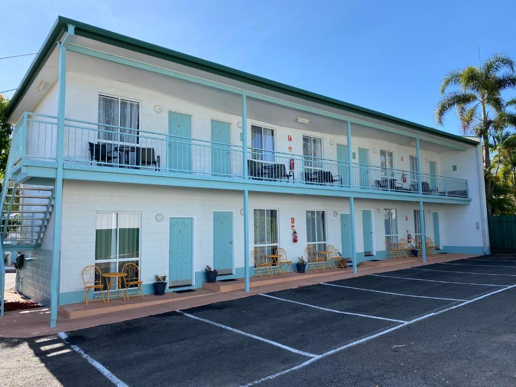 ein großes weißes Gebäude mit Parkplatz in der Unterkunft Central Point Motel in Mount Isa