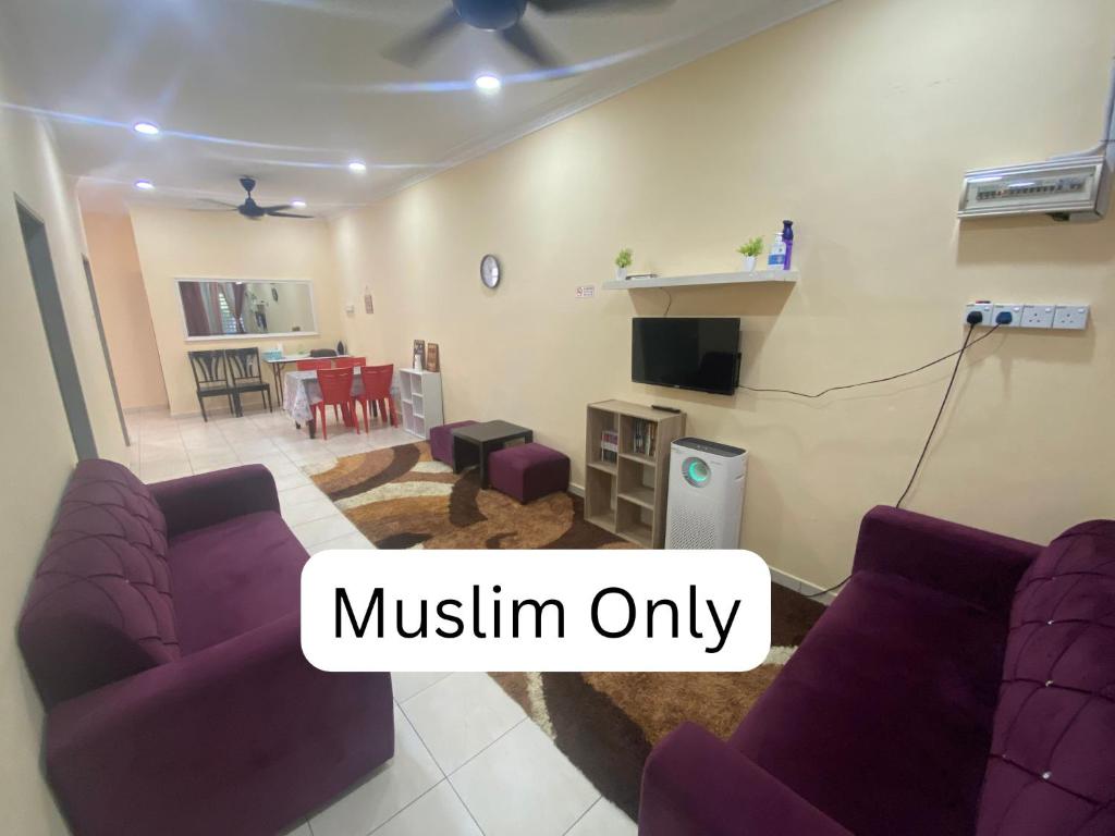 ein Wohnzimmer mit lila Sofas und ein Esszimmer in der Unterkunft Homestay Cikgu Muaz in Kuala Kangsar