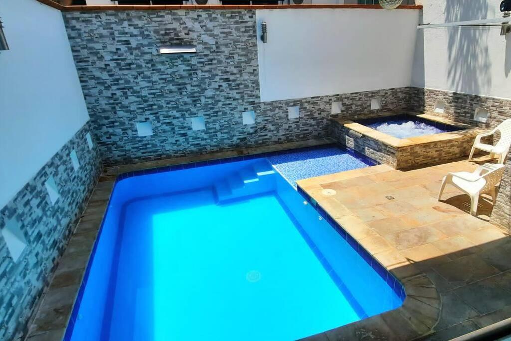 una piscina en una habitación con mesa y silla en Sol, piscina y jacuzzi privados., en Medellín