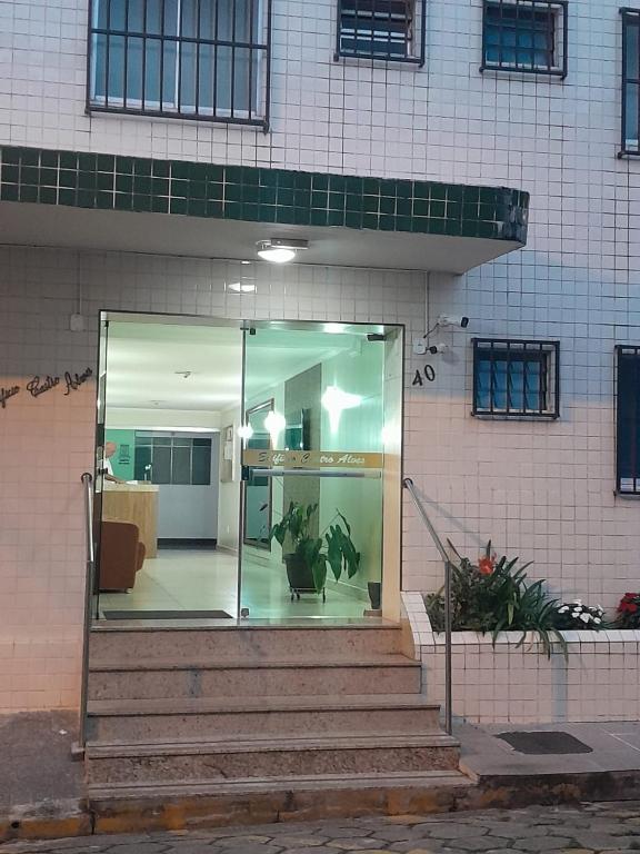 una entrada de cristal a un edificio con escaleras y plantas en Apartamento Aconchegante, en São Lourenço