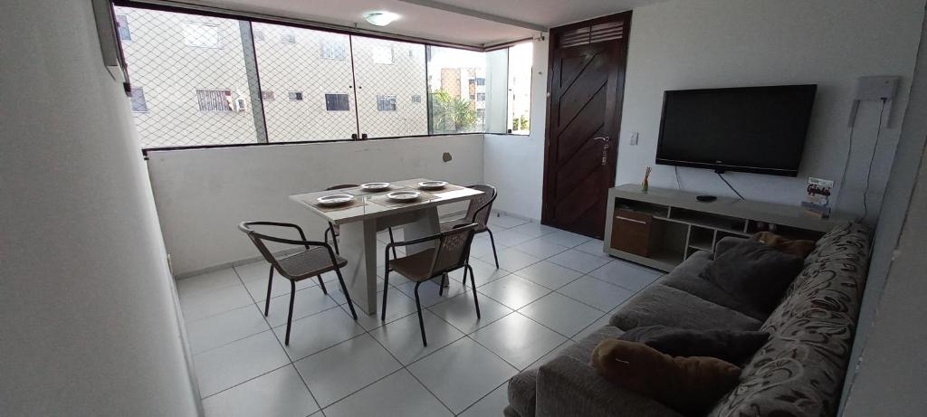 a living room with a table and a couch at Apartamento aconchegante e bastante espaçoso in Natal