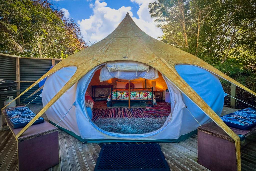 une tente avec un lit sur une terrasse dans l'établissement Te Tiro Accommodation, à Grottes de Waitomo