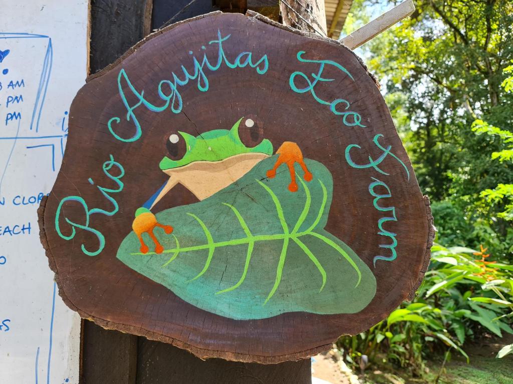 ein Schild für einen Garten mit einem Frosch darauf in der Unterkunft Rio Agujitas Eco jungle - Island and Corcovado tours in Drake
