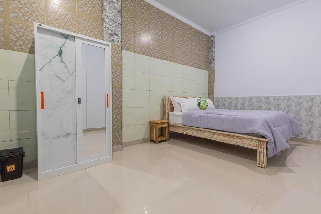 um quarto com uma cama e uma cabina de duche ao nível do chão em Bali DD homestay seminyak em Seminyak