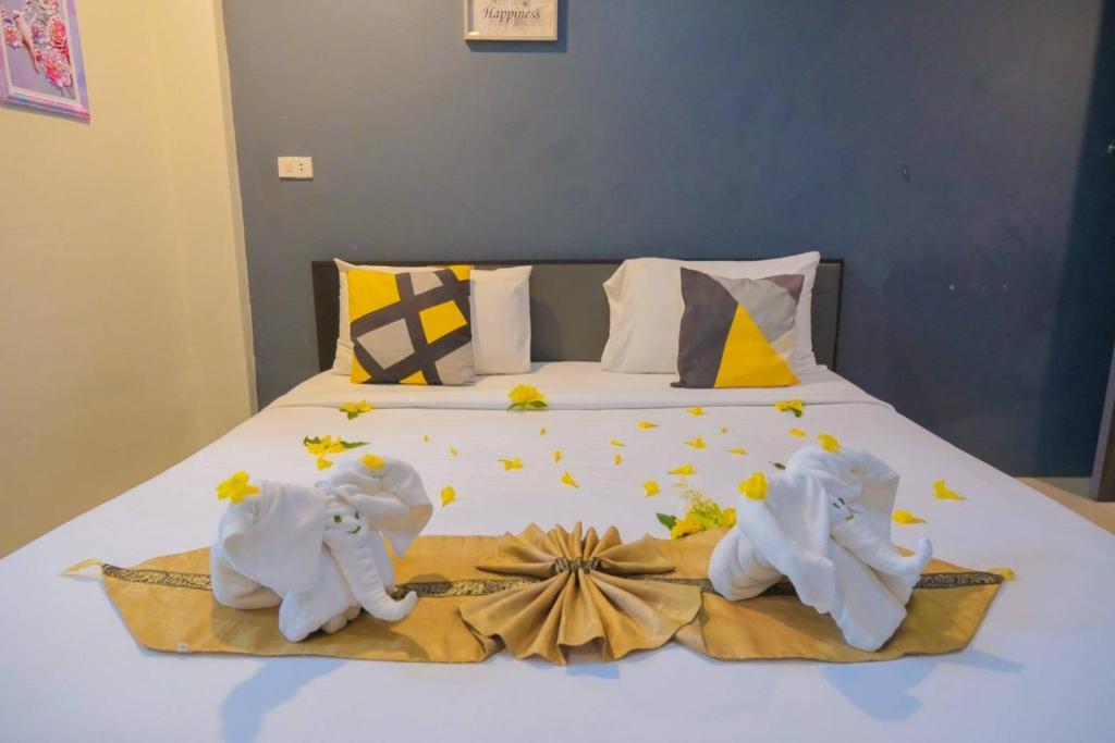 a bed with towels on it with flowers on it at โรงแรมศุภชัย อินน์ in Ban Ba Ngan