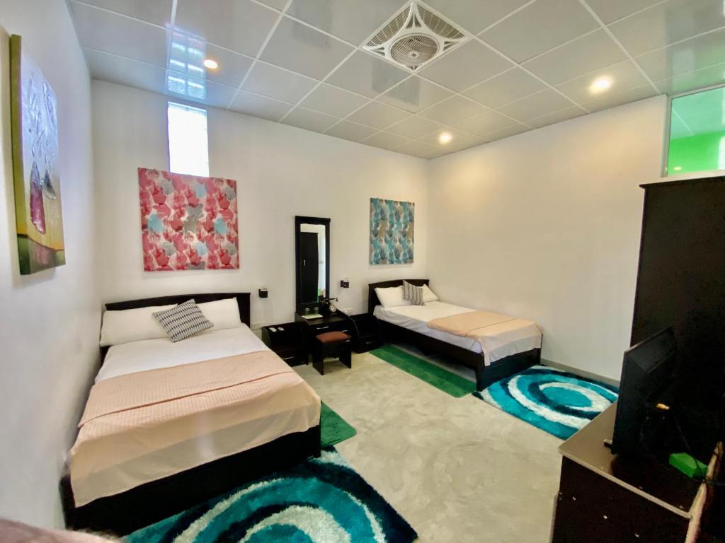 a bedroom with two beds and a flat screen tv at Green Villa in Oluvil