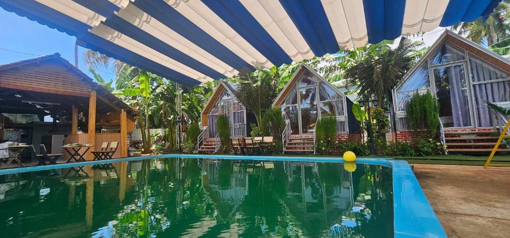 a swimming pool in front of a house at Dak Nguyen Homestay DakLak in Dak Lak