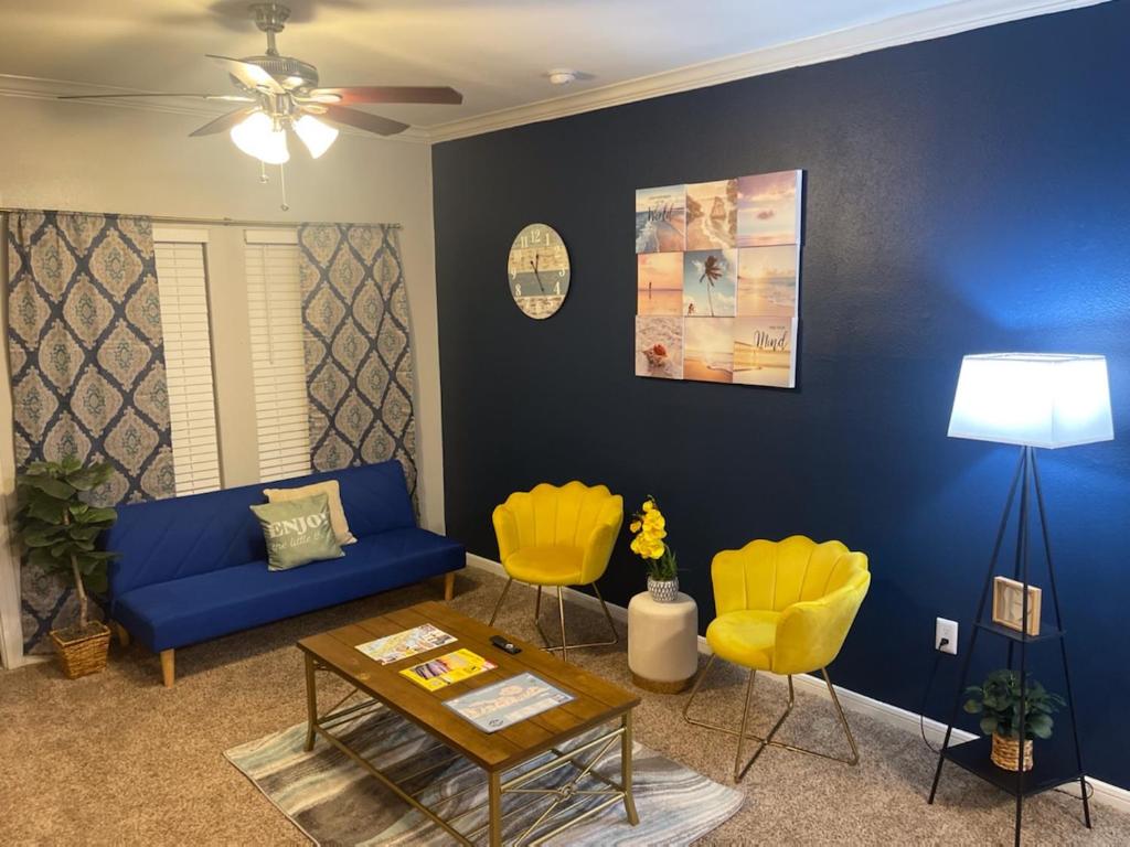 uma sala de estar com um sofá azul e cadeiras amarelas em New Listing!! Relax by the Beach!! 2 Queen Beds, 1 Sofa Couch, Free WiFi 2 TVs, Free Parking, Pool, Hot Tub, Gym , Elevator Accessible to property em Galveston