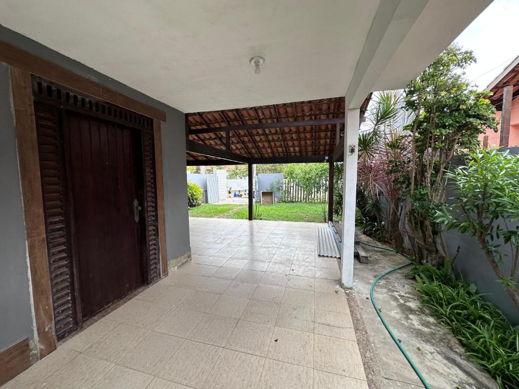 einen Eingang zu einem Haus mit einer braunen Tür in der Unterkunft Casa 4 quartos com piscina Grussai in São João da Barra