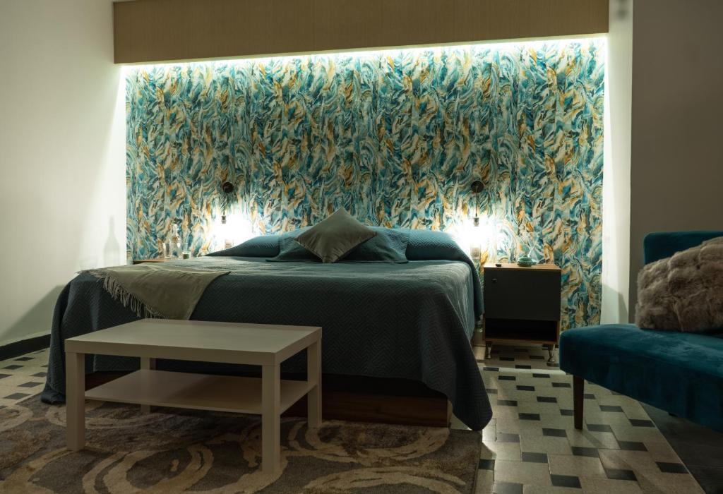 een slaapkamer met een bed en een blauwe muur bij Polanco - Suite 2 de Lujo en Nápoles Cama King Size in Mexico-Stad