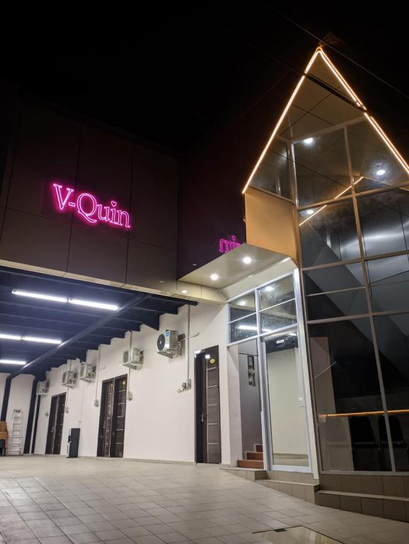 a building with a neon sign on the side of it at V Quin in Semarang