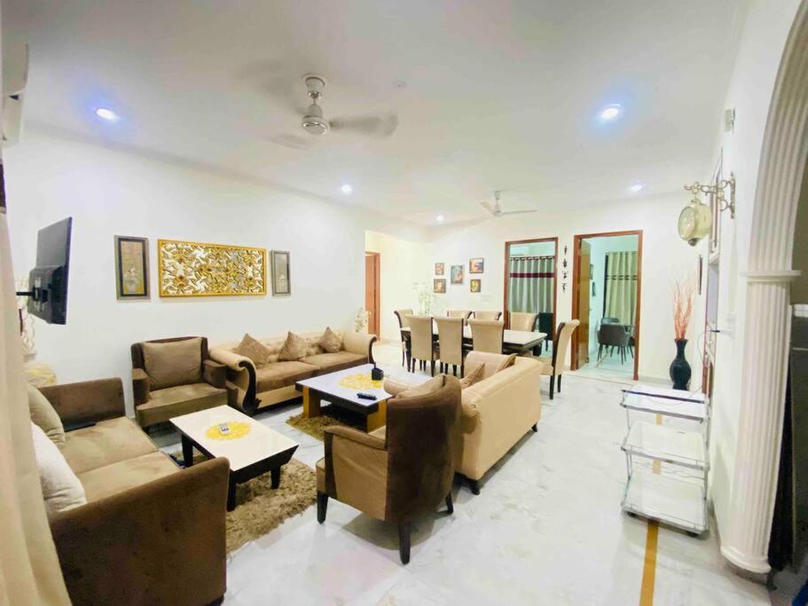 un ampio soggiorno con divani e tavolo di Luxurious Beautiful House Sector 70 noida a Noida