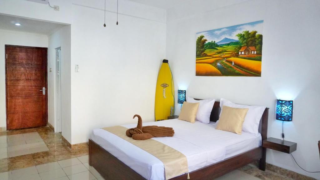 a bedroom with a bed with a swan on it at Balian Surf Club in Legian