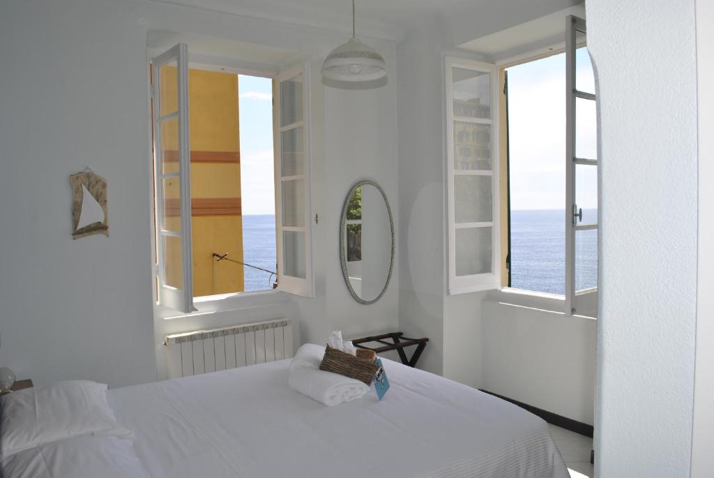 a white bedroom with a bed and two windows at Al Piccolo Scoglio - Room & Breakfast in Camogli