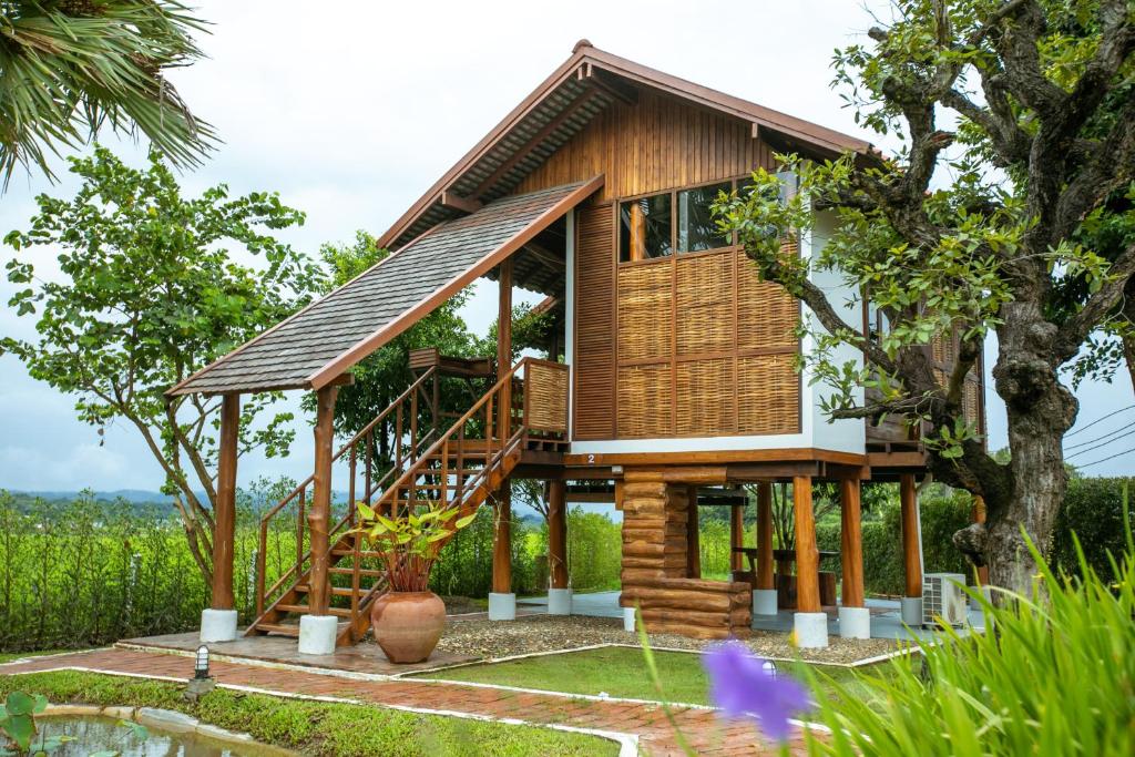 a house on stilts with a tree at Saksila Resort in Nan