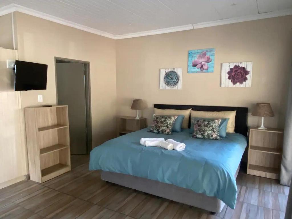 a bedroom with a bed with two towels on it at Aloe Guest Rooms in Bloemfontein