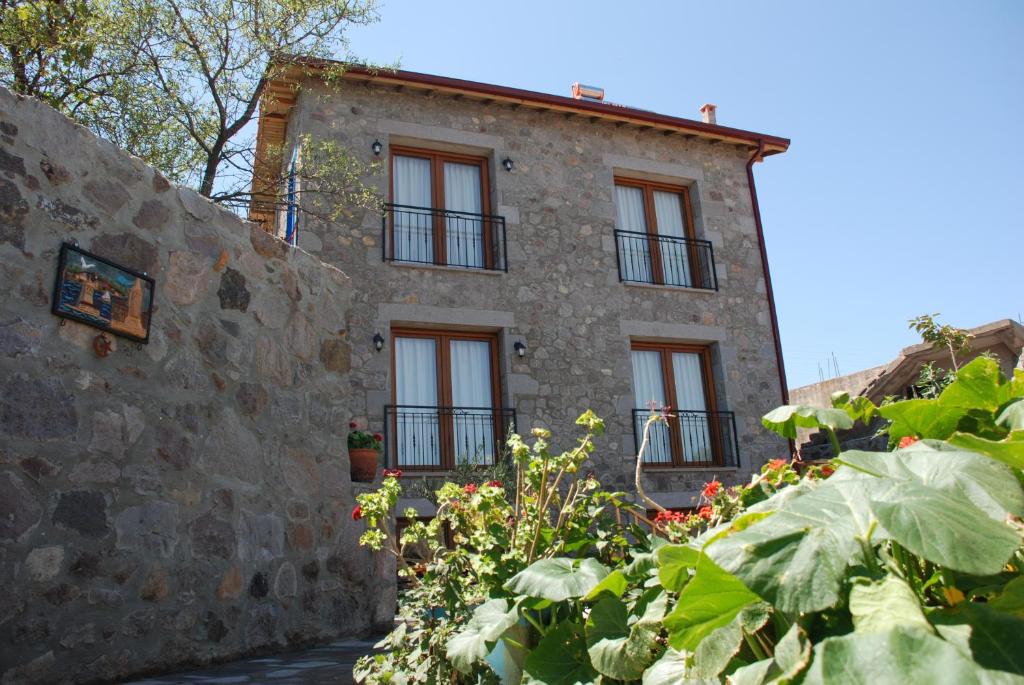 an old stone house with windows and plants at Olive Ranch Guest House in Bergas