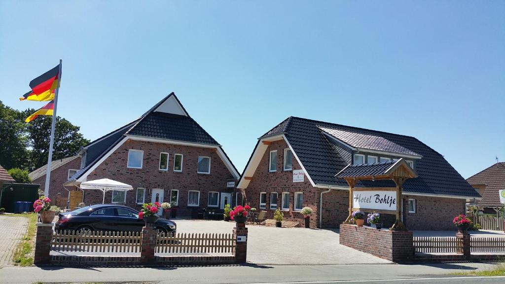 uma casa com uma bandeira em frente em Hotel Bohlje em Westerstede