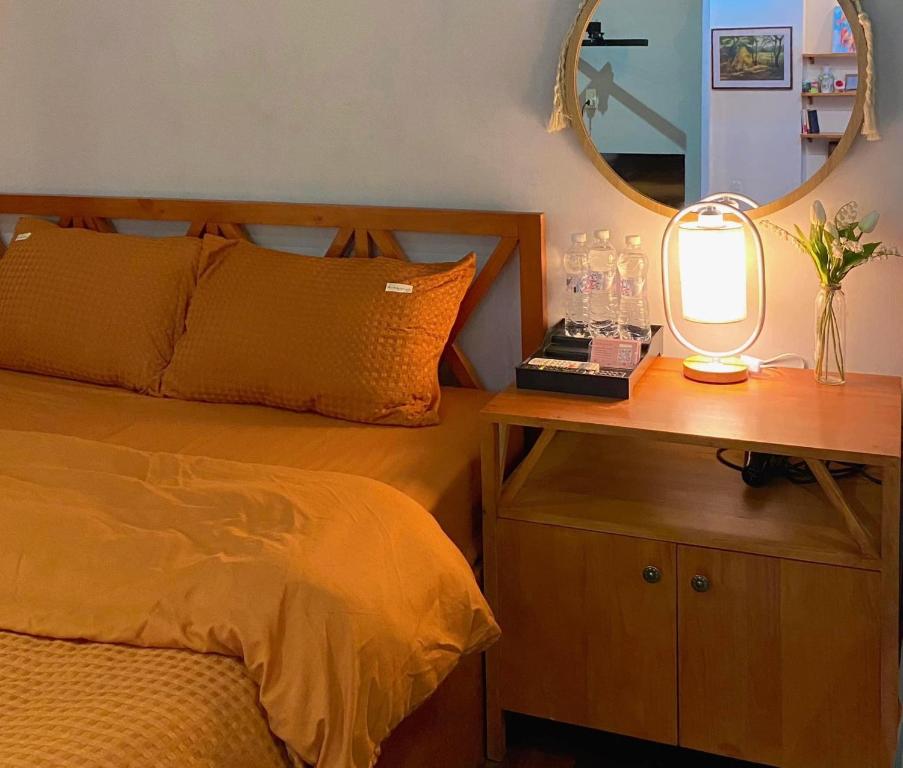 - une chambre avec un lit et une table avec un miroir dans l'établissement Ngáo Home, à Hanoï