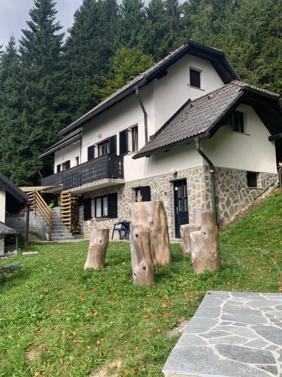 Uma casa com um monte de troncos à frente. em Apartments Nune em Zrece