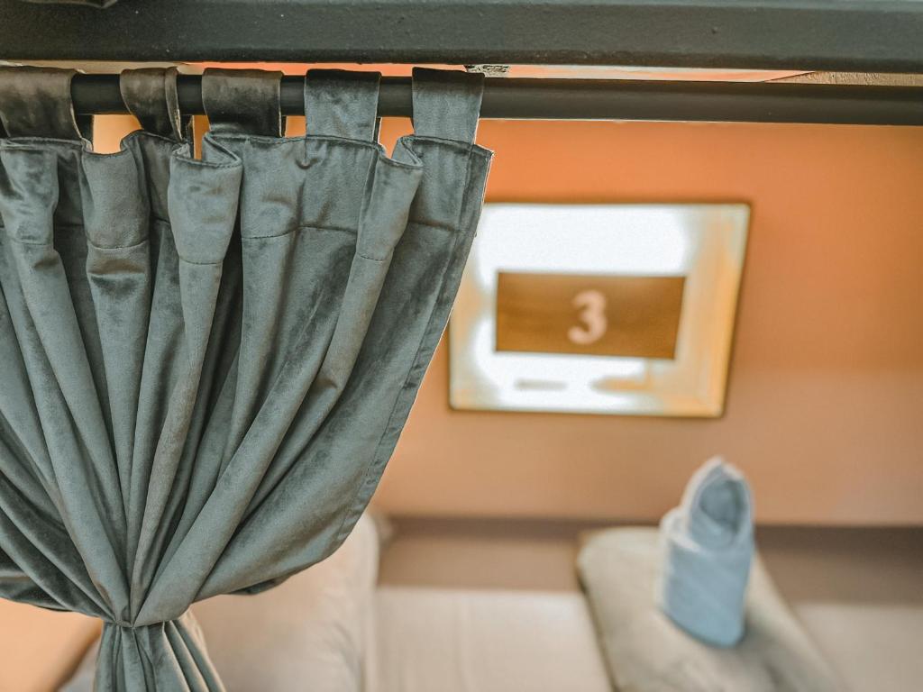 a curtain in a room with a clock on the wall at Outpost Hostel - Coron in Coron