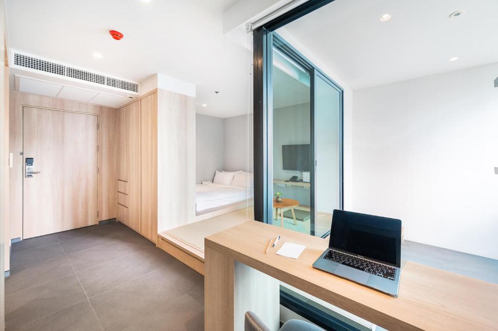 a room with a desk with a laptop on it at LiveZen Bangkok Sukhumvit in Khlong Toei
