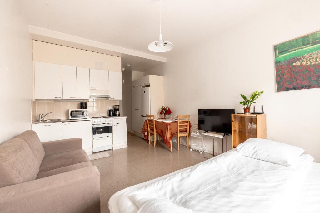 ein Wohnzimmer mit einem Sofa und einer Küche in der Unterkunft 2ndhomes Bright & Compact Studio with the best loc in Helsinki