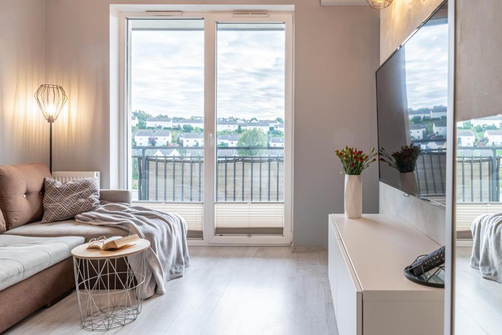 sala de estar con sofá y ventana grande en Apartament Nad Stawem, en Gdansk