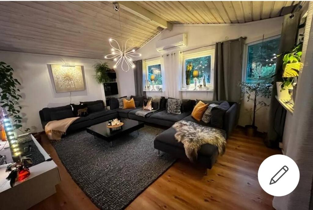 uma sala de estar com um sofá e uma mesa em En liten trevlig villa nära stranden och travbanan. em Eskilstuna