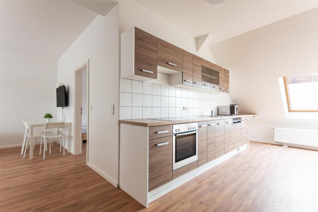 eine Küche mit weißen Wänden und Holzschränken in der Unterkunft T&K Apartments - DUISBURG - Frisch renovierte 4 Zimmer Maisonetten mit Privatparkplätzen in Duisburg