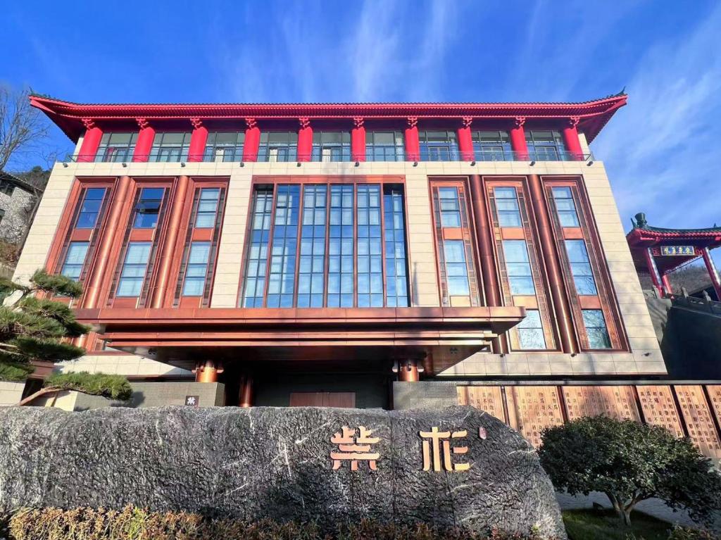 un edificio con una señal delante de él en Wudang Mountain The Yew House en Wudangshan