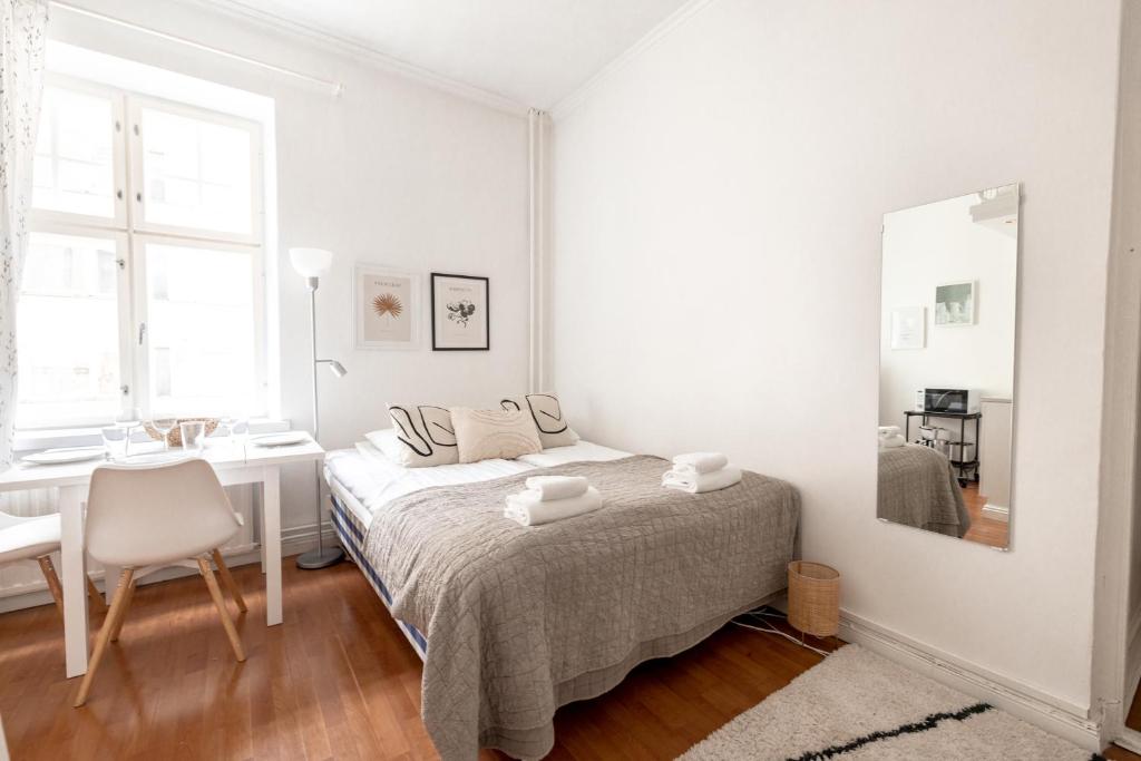 a white bedroom with a bed and a desk at 2ndhomes Cozy and Compact studio in Kamppi in Helsinki