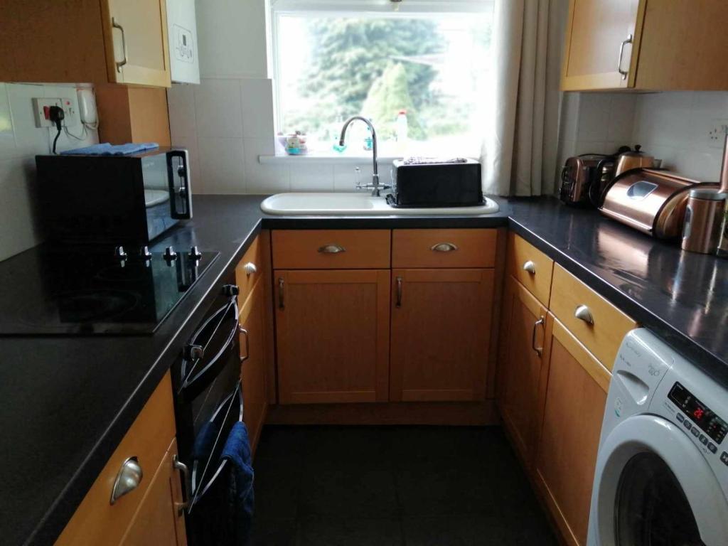 a kitchen with a sink and a washing machine at Beacons view in Hirwaun