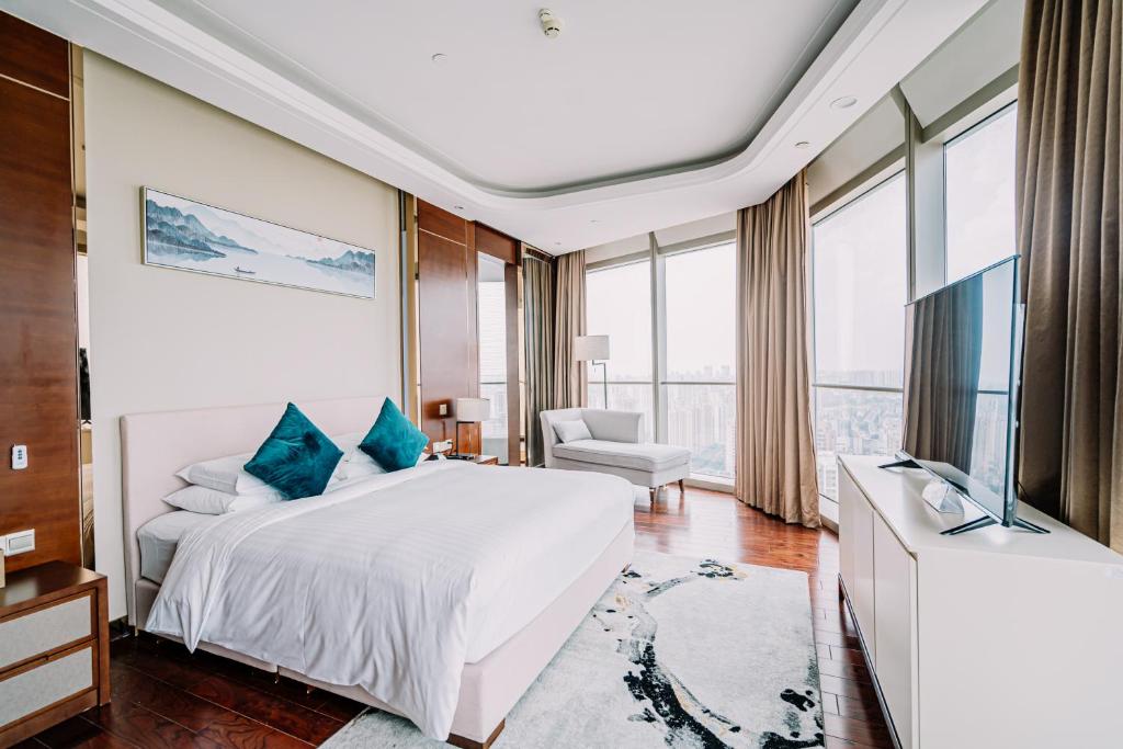 Habitación de hotel con cama y TV en The Grand View Hotel Changzhou, en Changzhou
