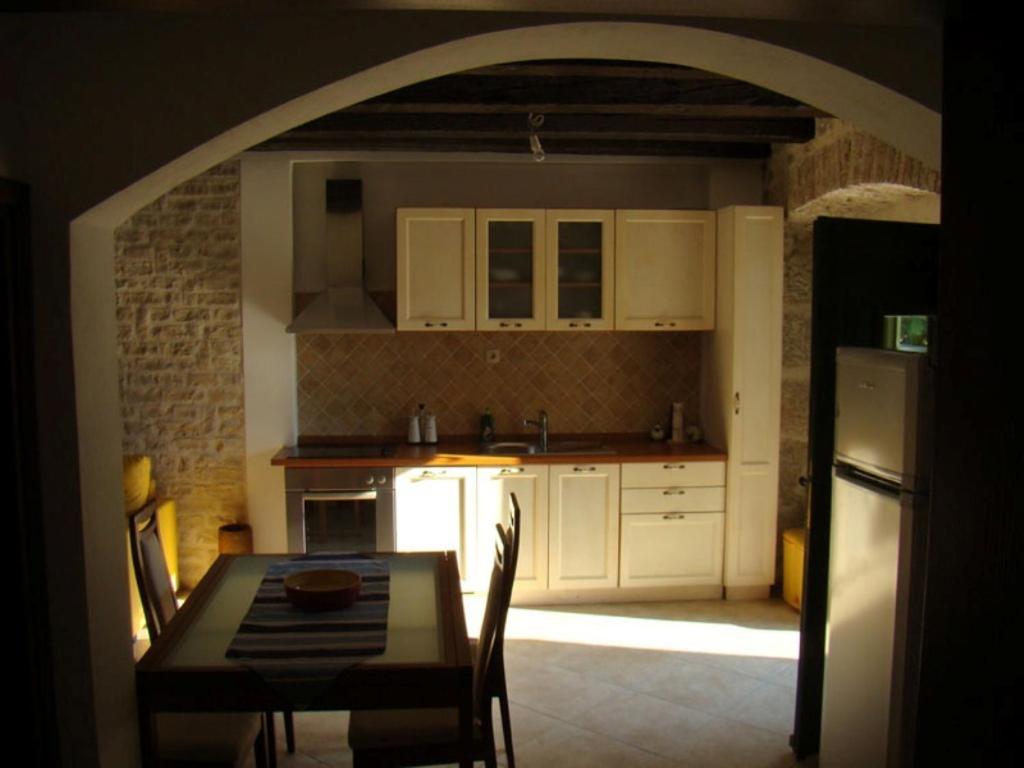 a kitchen with a table and a kitchen with white cabinets at Apartment Lasan in Vodice